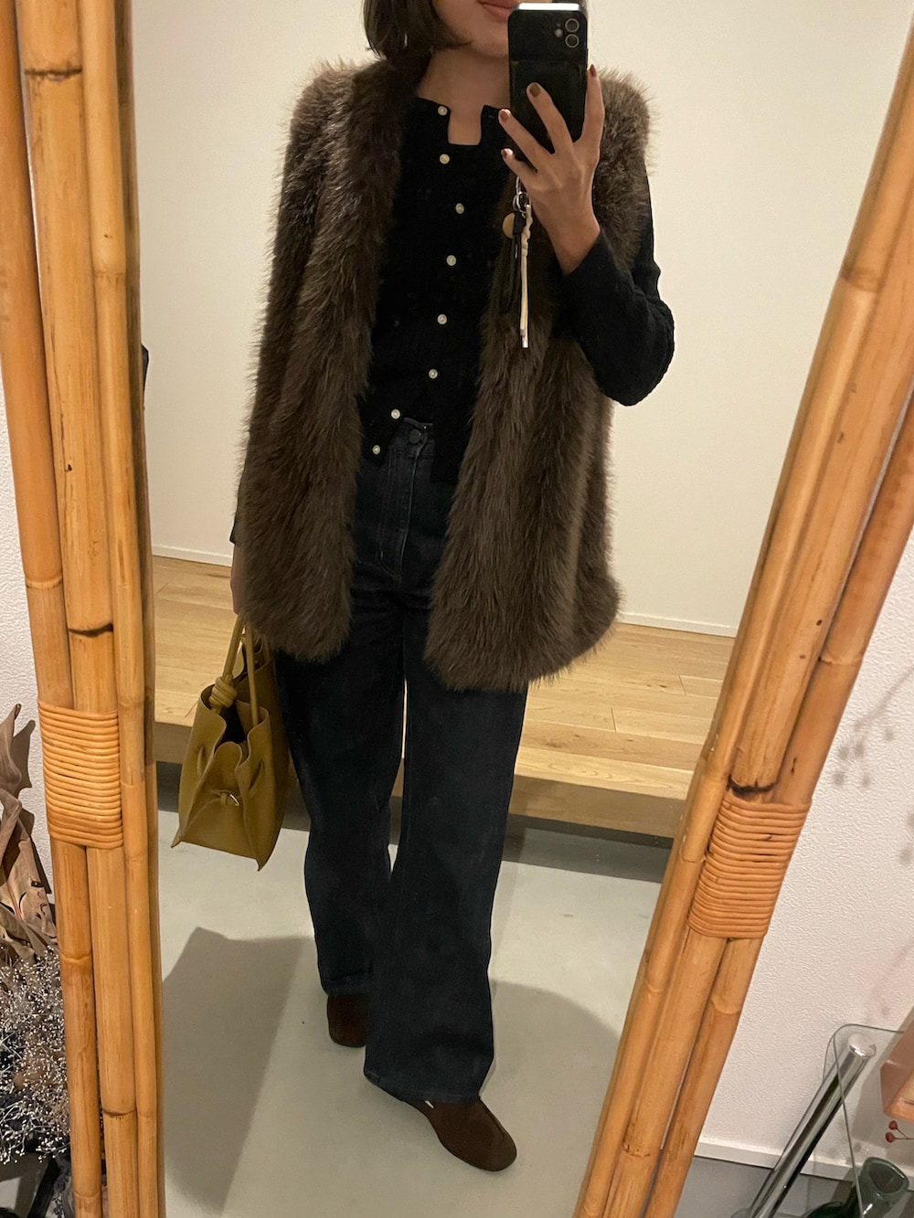 ブラック系のカーディガン/ボレロ、ブラウン系のベスト、ブラウン系のローファーを着用したレディースの秋コーディネートの2枚目の写真