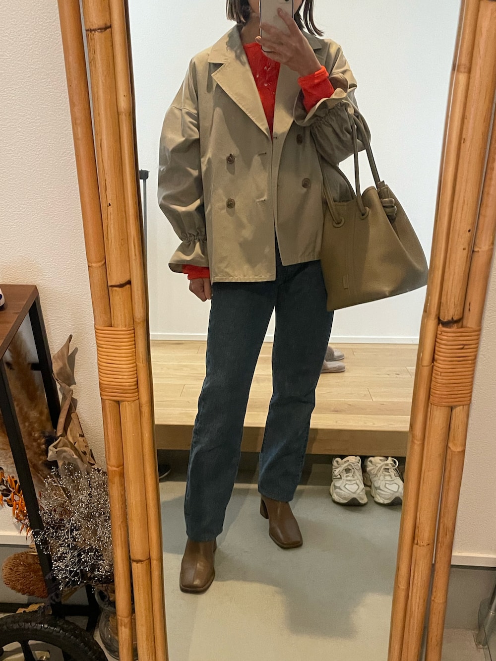 ブルー系のデニムパンツ、ベージュ系のバッグ、ブラウン系のブーツを着用したレディースの春コーディネートの3枚目の写真