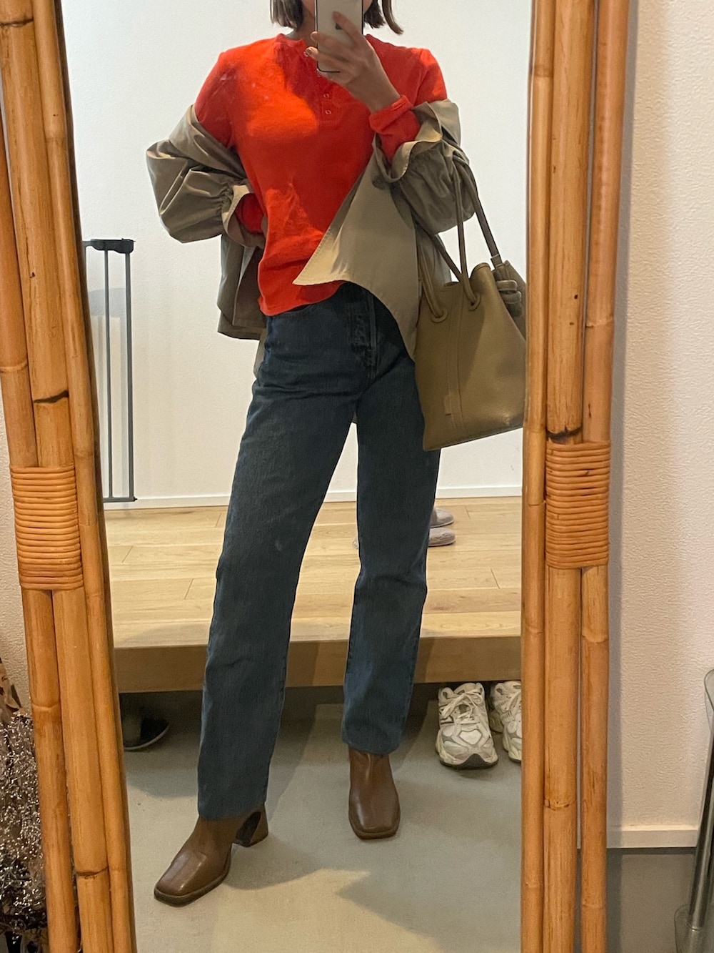 ブルー系のデニムパンツ、ベージュ系のバッグ、ブラウン系のブーツを着用したレディースの春コーディネートの5枚目の写真