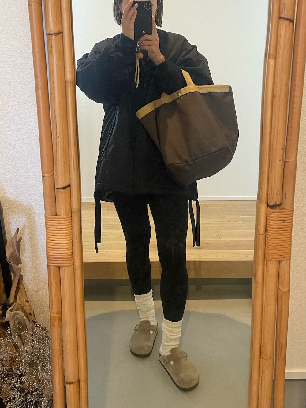 ブラウン系のトートバッグ、ブラック系のMA-1、ブラック系のその他パンツを着用したレディースの冬コーディネートの2枚目の写真