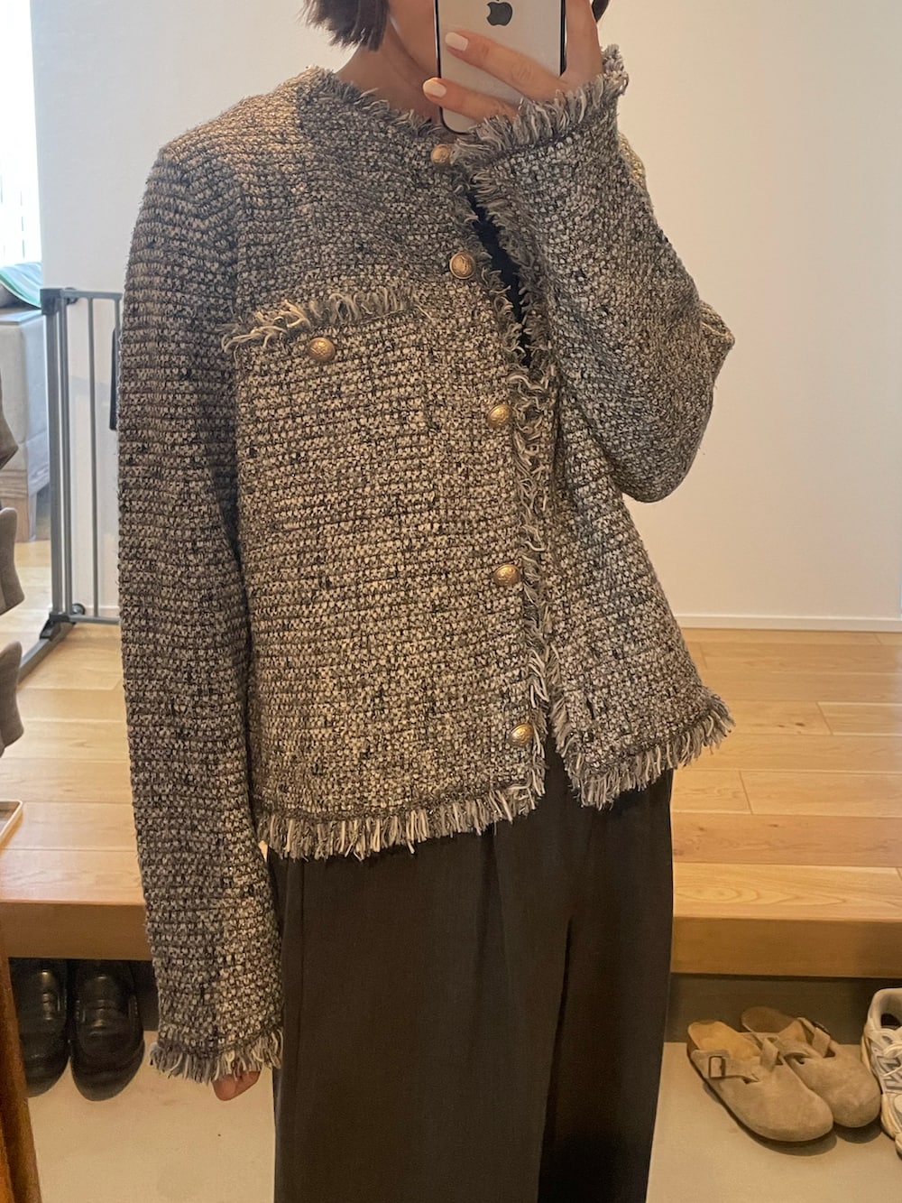 ブラック系のノーカラージャケット、グレー系のスラックス、ベージュ系のパンプスを着用したレディースの冬コーディネートの3枚目の写真