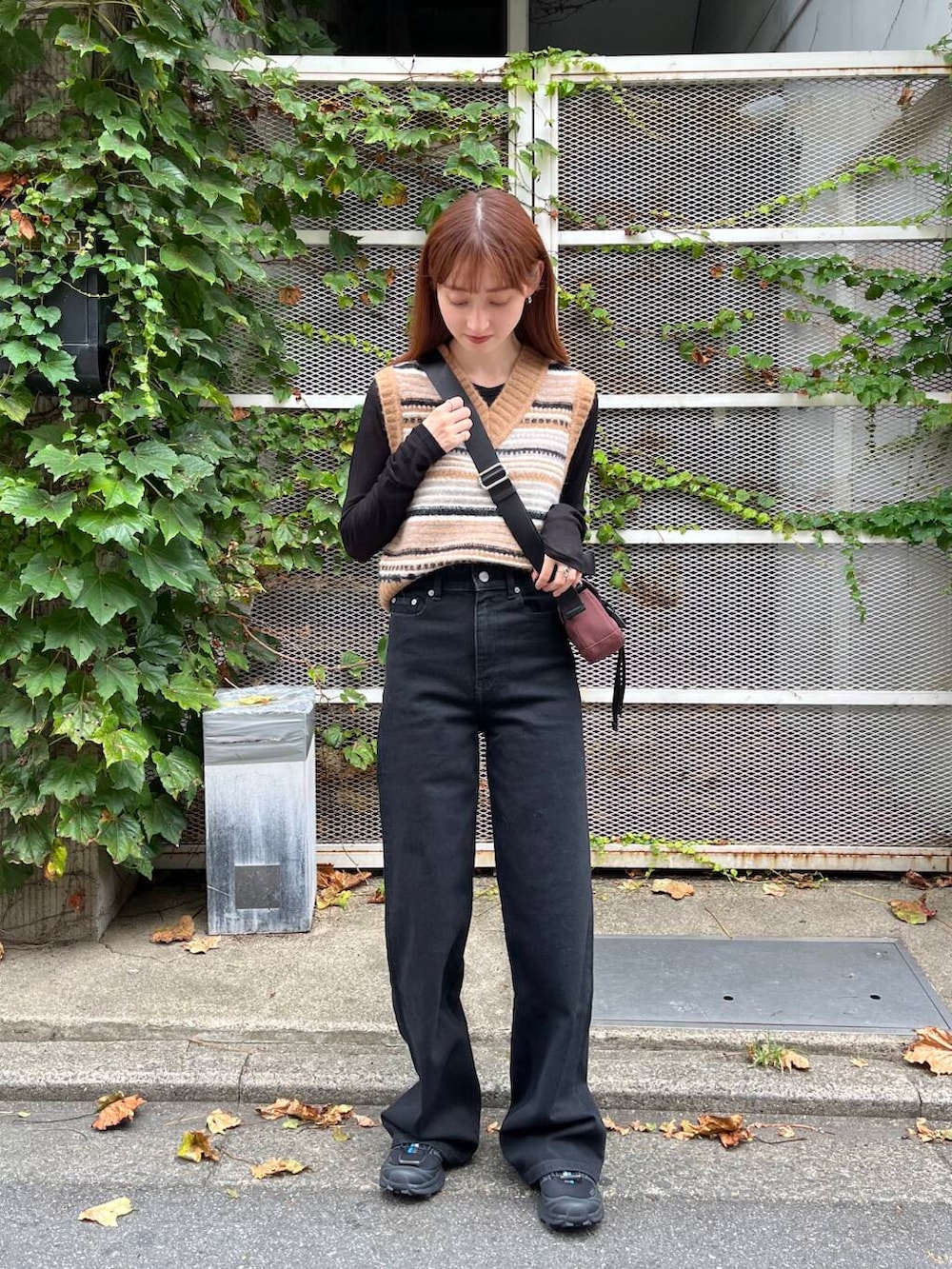 ブラック系のTシャツ/カットソー、ブラック系のスニーカー、ブラウン系のベストを着用したレディースの夏コーディネートの2枚目の写真