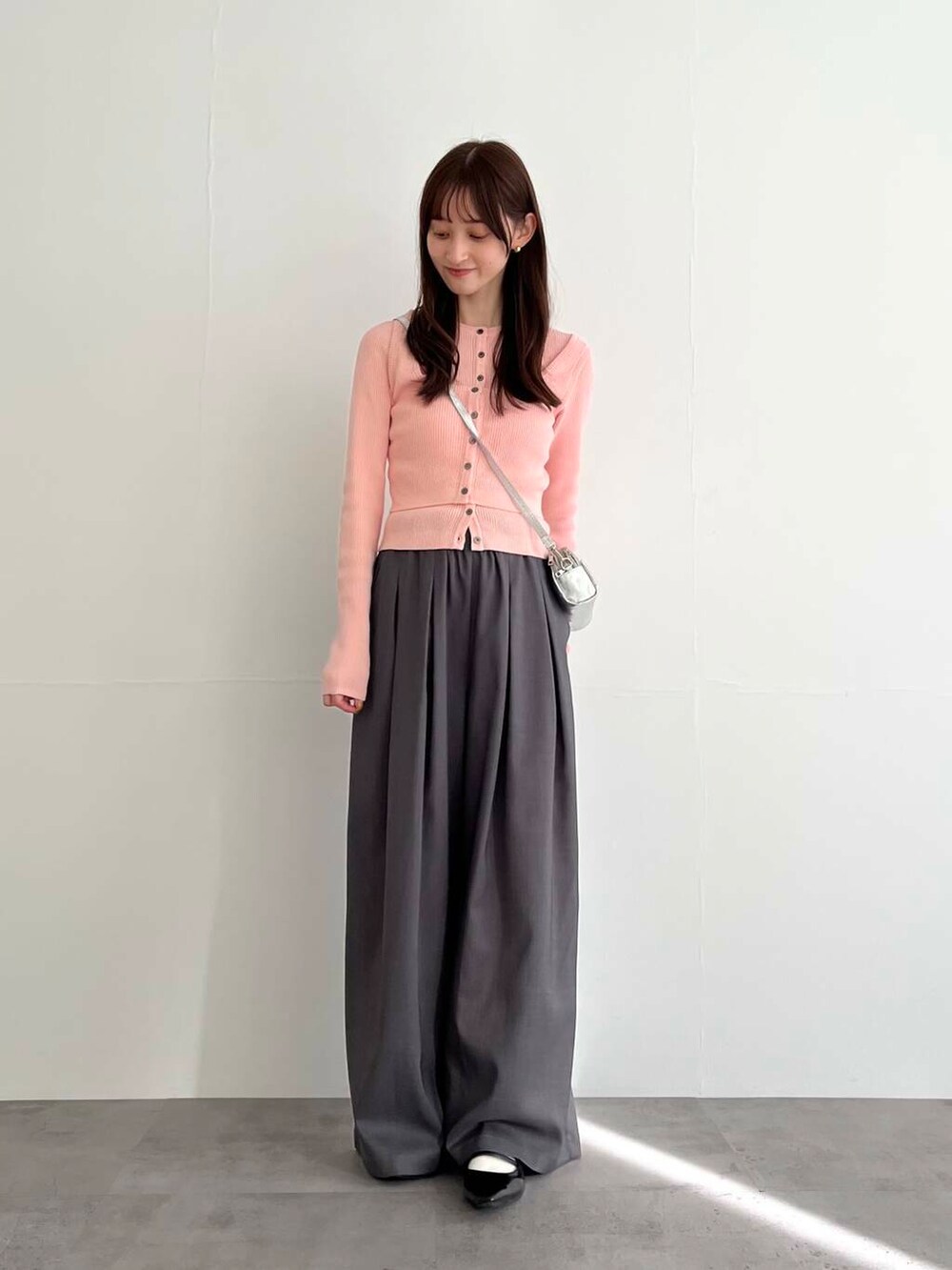 グレー系のその他パンツ、シルバー系のショルダーバッグ、ピンク系のベストを着用したレディースの冬コーディネートの2枚目の写真