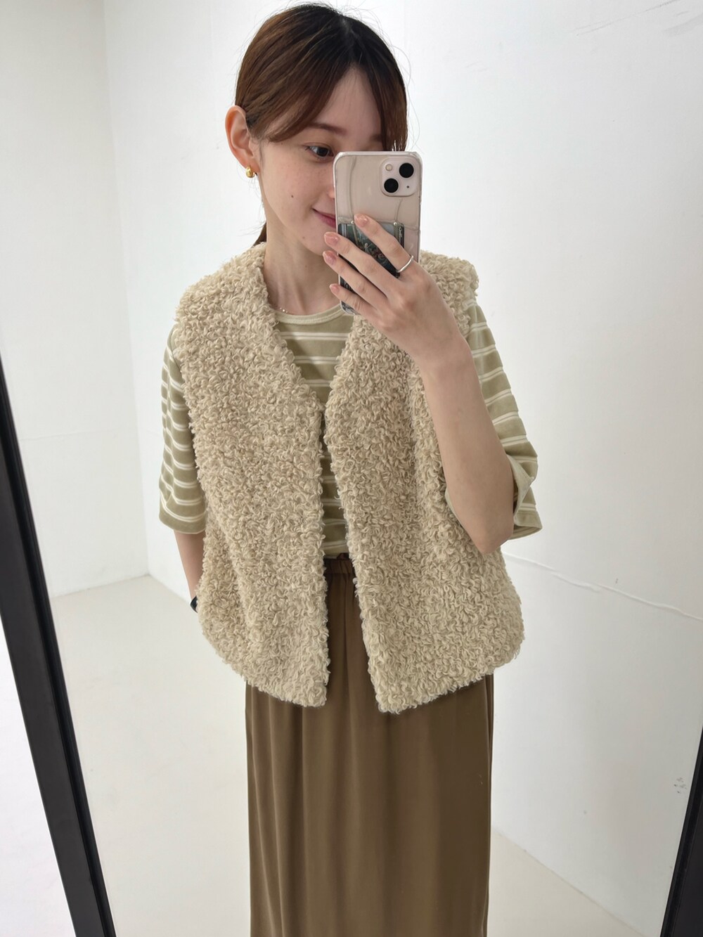 ホワイト系のベスト、ベージュ系のスカート、ベージュ系のパンプスを着用したレディースの夏コーディネートの5枚目の写真