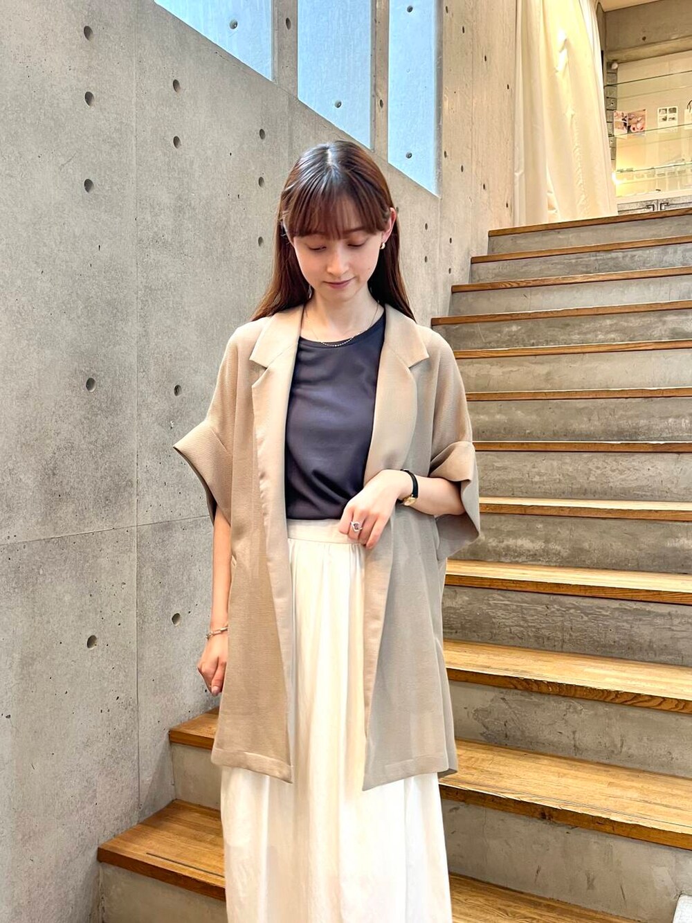 グレー系のTシャツ/カットソー、ブラック系のサンダル、ホワイト系のスカートを着用したレディースの夏コーディネートの10枚目の写真