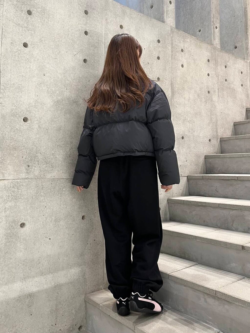 ホワイト系のTシャツ/カットソー、ブラック系のダウンジャケット/コート、ブラック系のスニーカーを着用したレディースの冬コーディネートの7枚目の写真