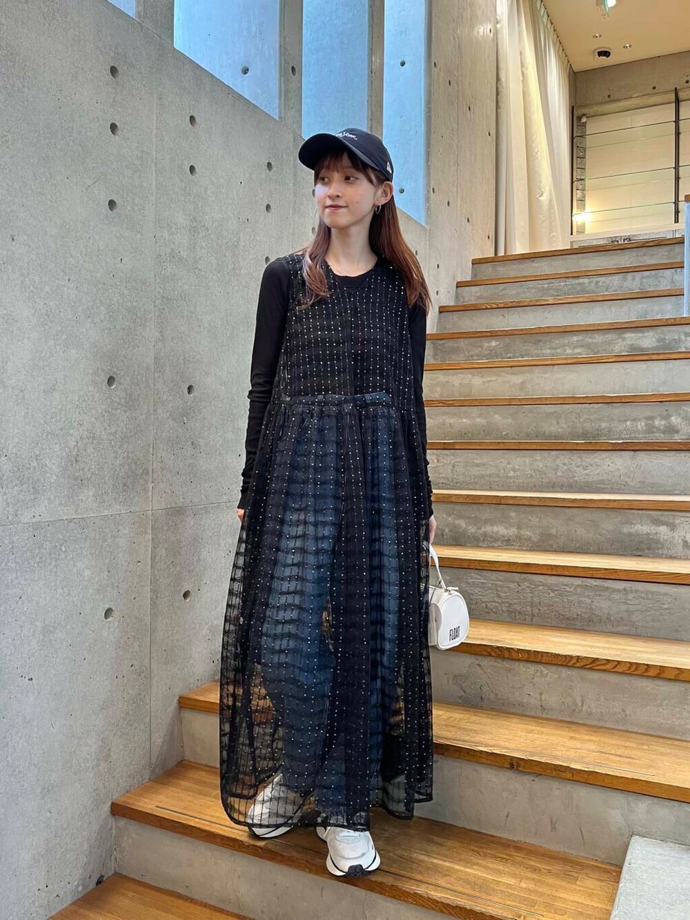 ブラック系のTシャツ/カットソー、ブルー系のデニムパンツ、ホワイト系のスニーカーを着用したレディースの夏コーディネートの3枚目の写真