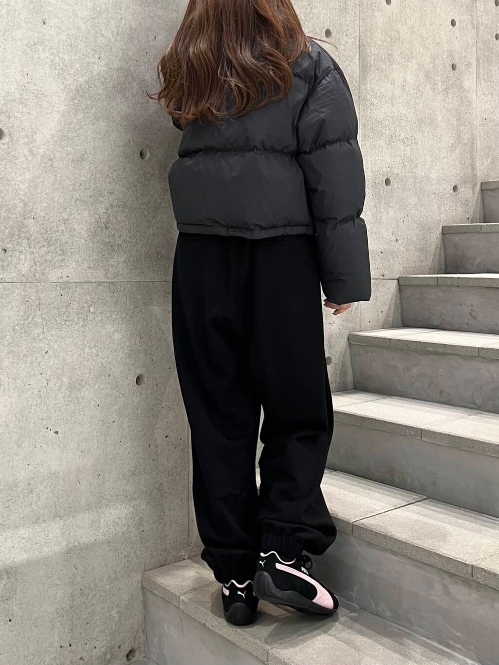 ホワイト系のTシャツ/カットソー、ブラック系のダウンジャケット/コート、ブラック系のスニーカーを着用したレディースの冬コーディネートの8枚目の写真