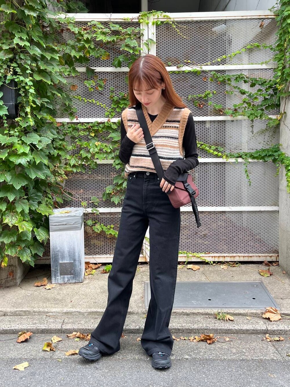 ブラック系のTシャツ/カットソー、ブラック系のスニーカー、ブラウン系のベストを着用したレディースの夏コーディネートの4枚目の写真