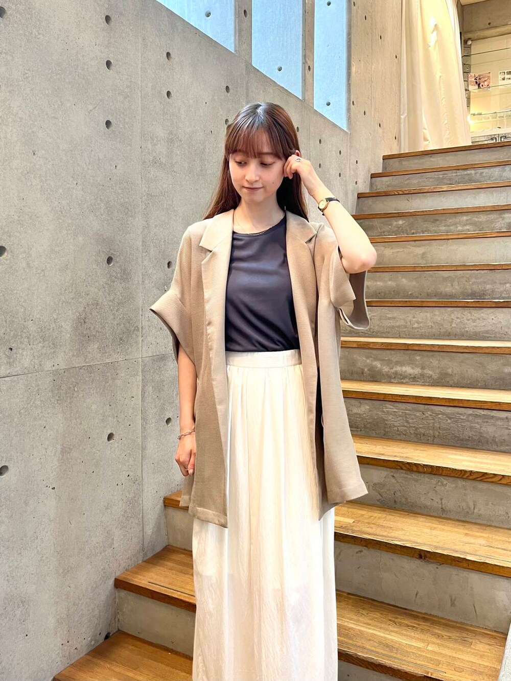 グレー系のTシャツ/カットソー、ブラック系のサンダル、ホワイト系のスカートを着用したレディースの夏コーディネートの9枚目の写真