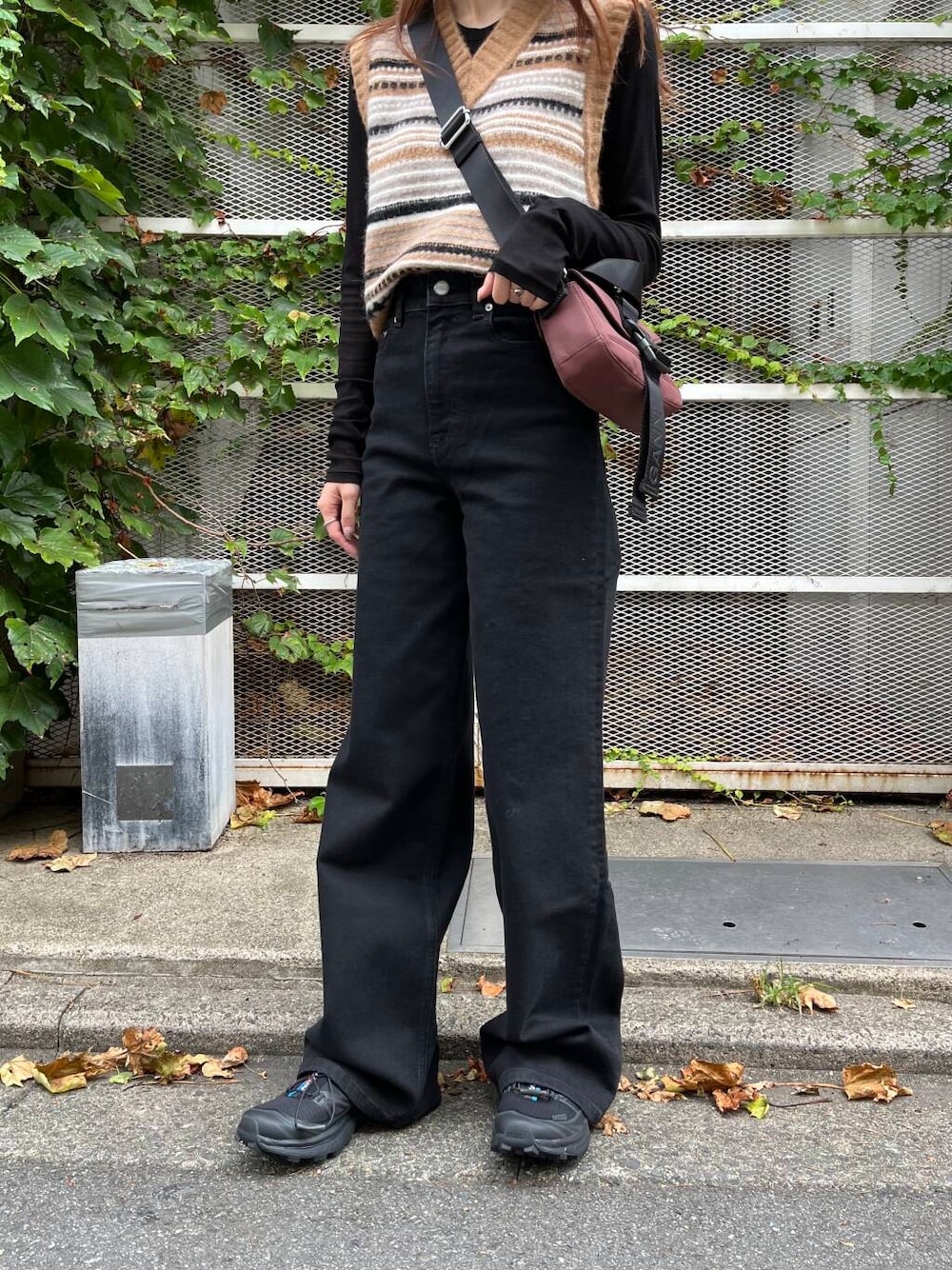 ブラック系のTシャツ/カットソー、ブラック系のスニーカー、ブラウン系のベストを着用したレディースの夏コーディネートの10枚目の写真