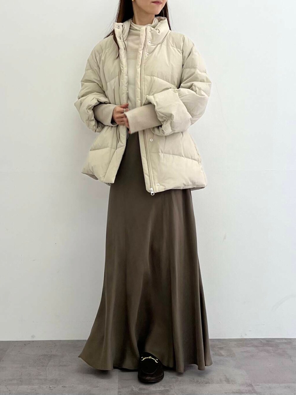 ホワイト系のダウンジャケット/コート、グリーン系のスカート、ホワイト系のTシャツ/カットソーを着用したレディースの冬コーディネートの5枚目の写真