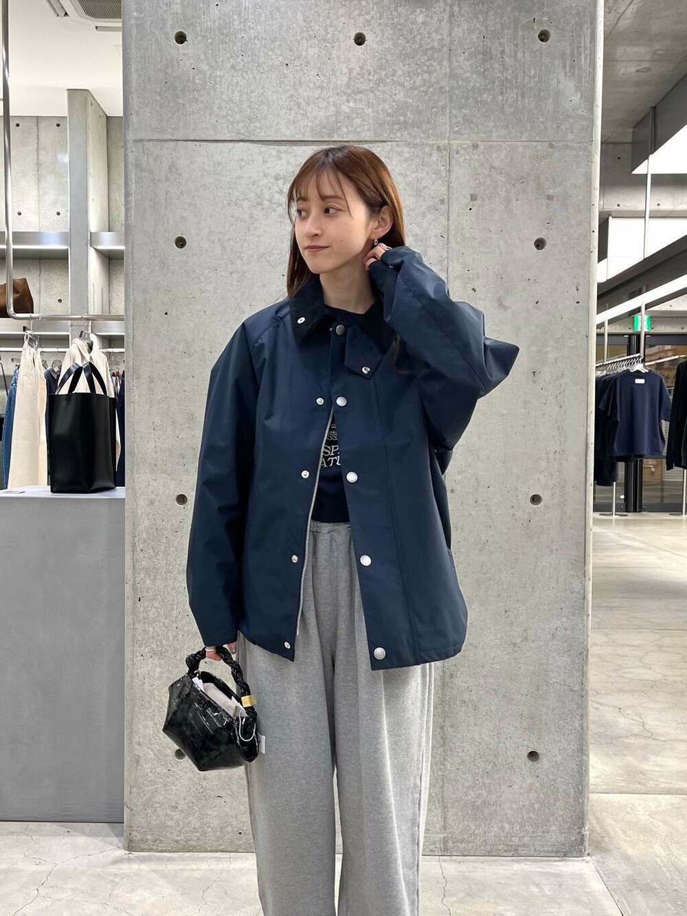 ブルー系のスウェット、ブラック系のショルダーバッグ、ブルー系のナイロンジャケットを着用したレディースの冬コーディネートの8枚目の写真