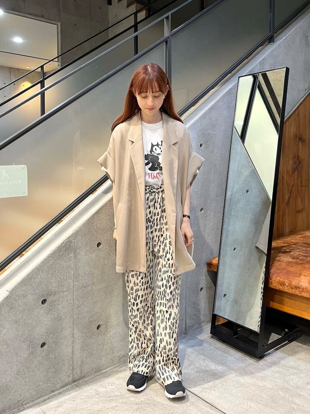 ホワイト系のTシャツ/カットソー、ベージュ系のテーラードジャケット、ブラック系のスニーカーを着用したレディースの夏コーディネートの2枚目の写真