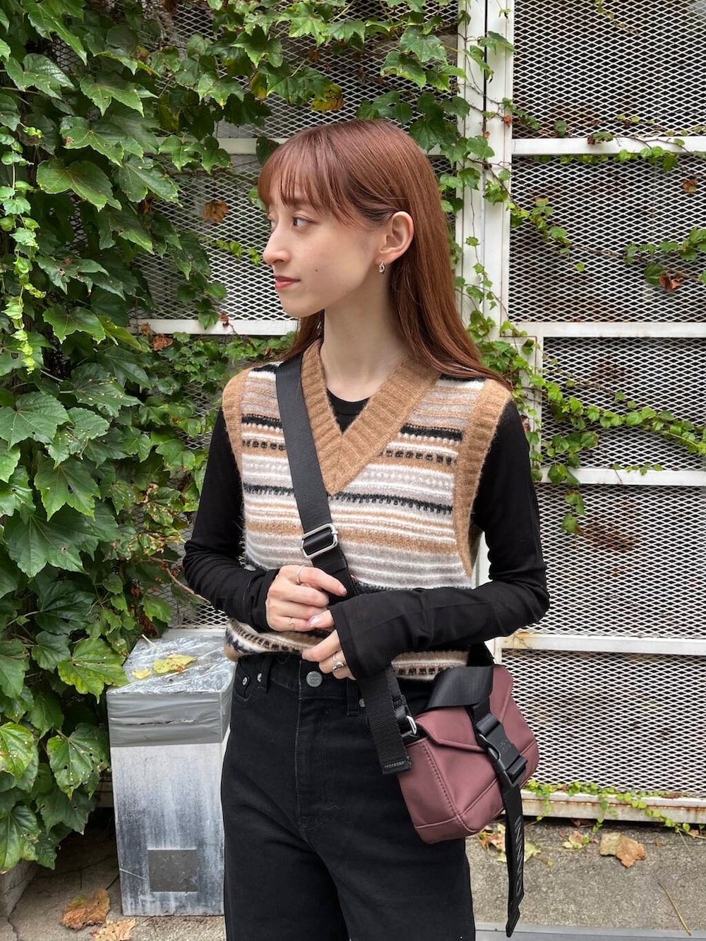 ブラック系のTシャツ/カットソー、ブラック系のスニーカー、ブラウン系のベストを着用したレディースの夏コーディネートの8枚目の写真