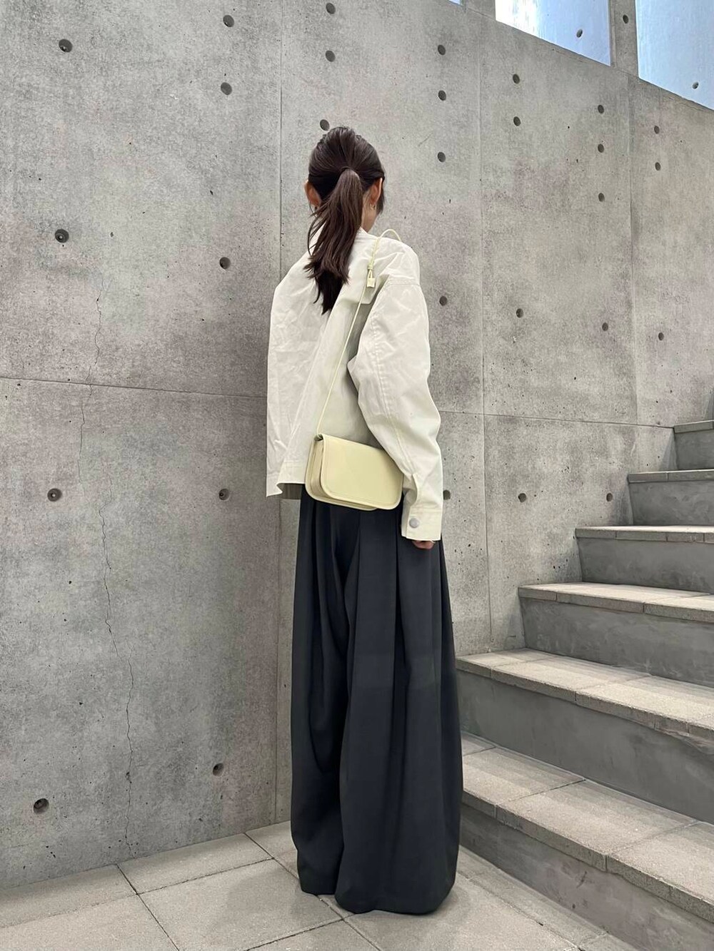 グレー系のその他パンツ、ホワイト系のショルダーバッグ、ブルー系のニット/セーターを着用したレディースの冬コーディネートの6枚目の写真