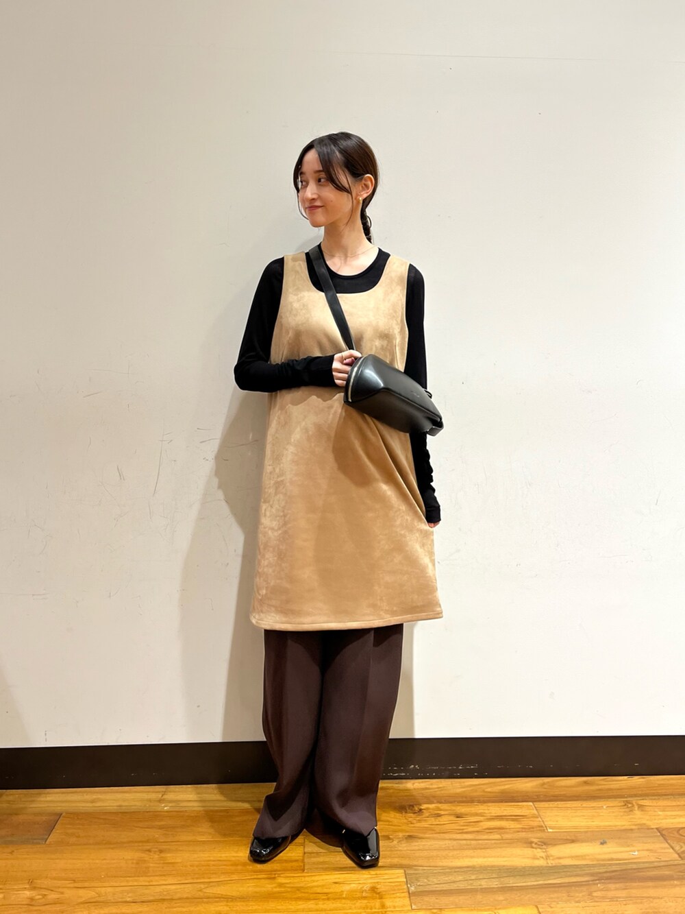 ベージュ系のワンピース、ブラック系のTシャツ/カットソー、ブラック系のローファーを着用したレディースの秋コーディネートの3枚目の写真