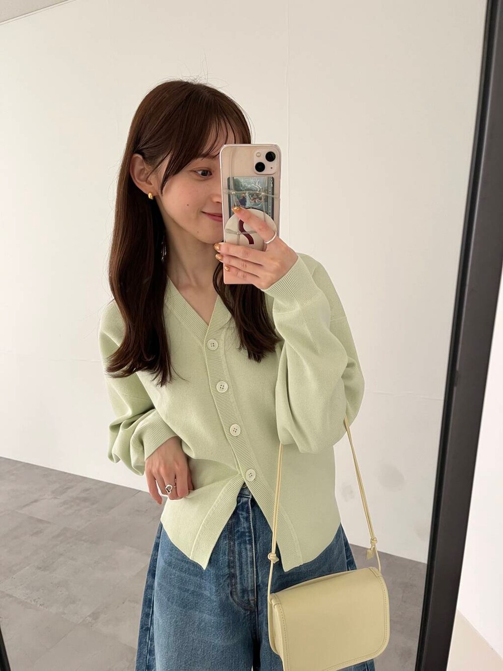 ブルー系のデニムパンツ、ホワイト系のショルダーバッグ、ホワイト系のスニーカーを着用したレディースの冬コーディネートの7枚目の写真