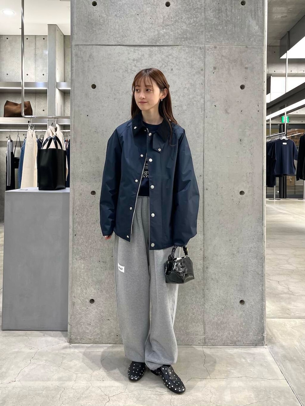 ブルー系のスウェット、ブラック系のショルダーバッグ、ブルー系のナイロンジャケットを着用したレディースの冬コーディネートの2枚目の写真