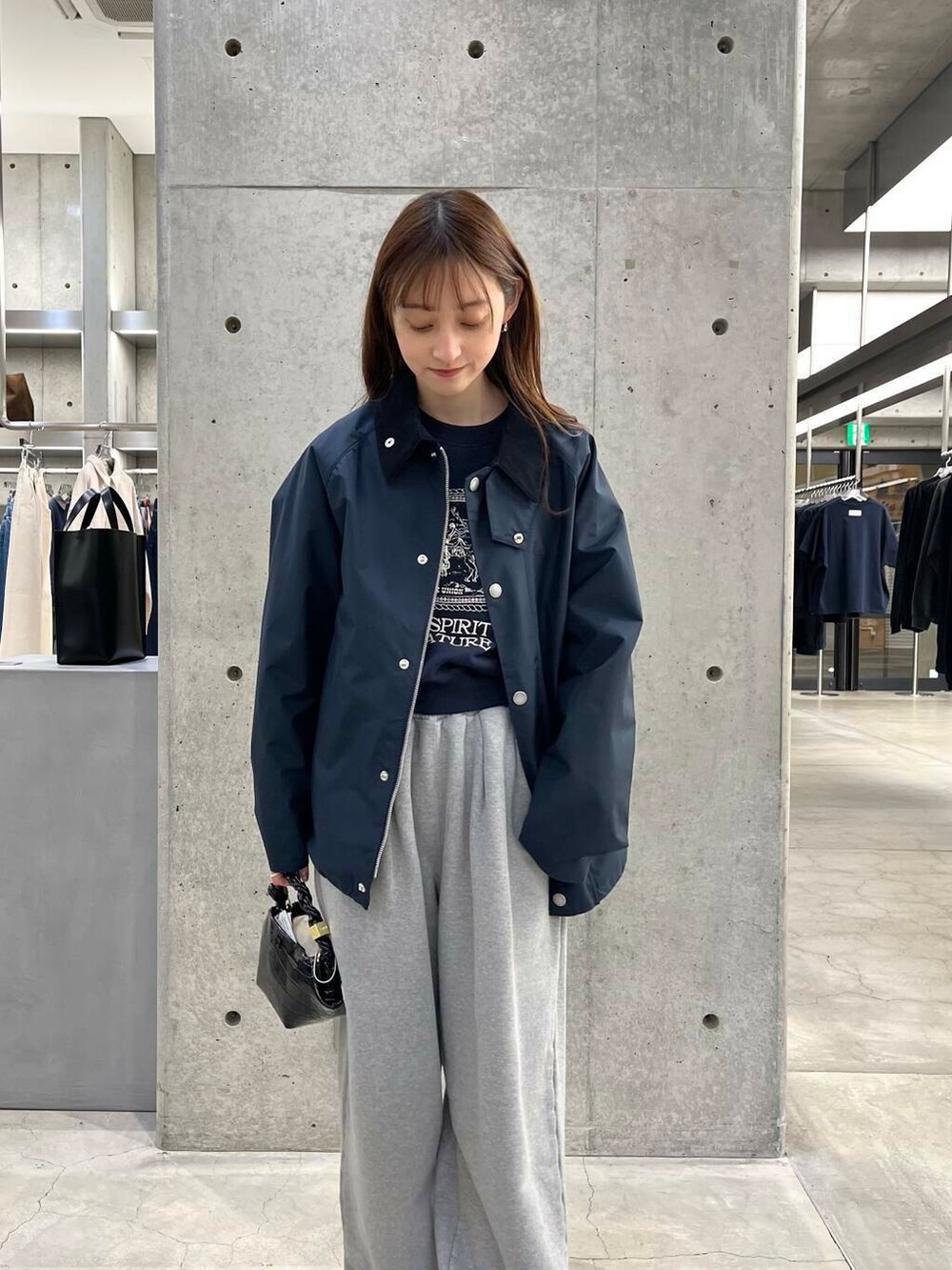 ブルー系のスウェット、ブラック系のショルダーバッグ、ブルー系のナイロンジャケットを着用したレディースの冬コーディネートの7枚目の写真