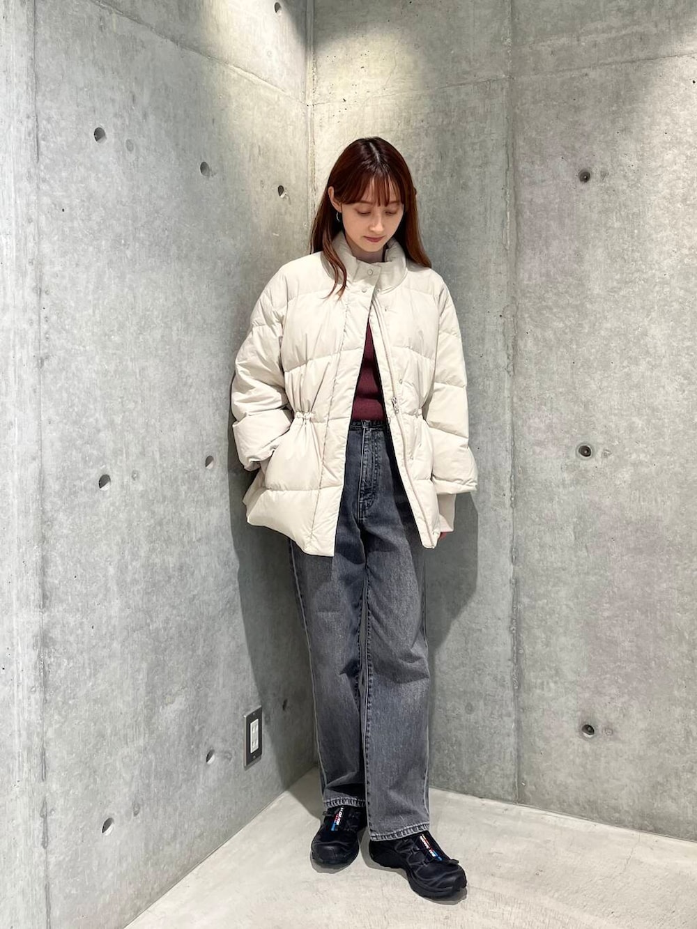 ブラック系のデニムパンツ、ブラック系のスニーカー、ホワイト系のダウンジャケット/コートを着用したレディースの秋コーディネートの2枚目の写真