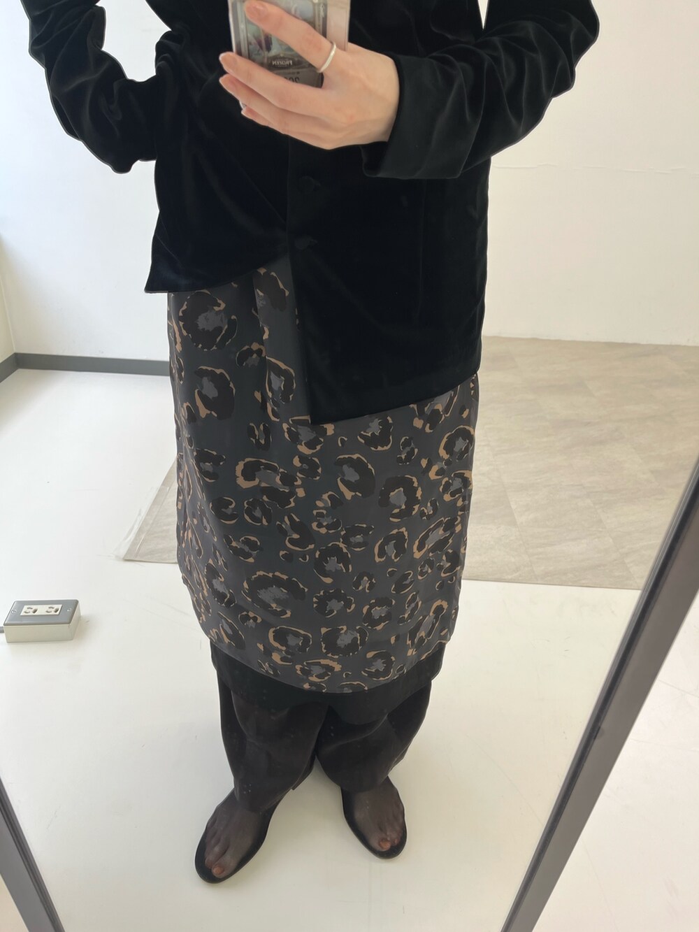 ブラック系のカーディガン/ボレロ、グレー系のスカート、ブラウン系のその他パンツを着用したレディースの秋コーディネートの4枚目の写真