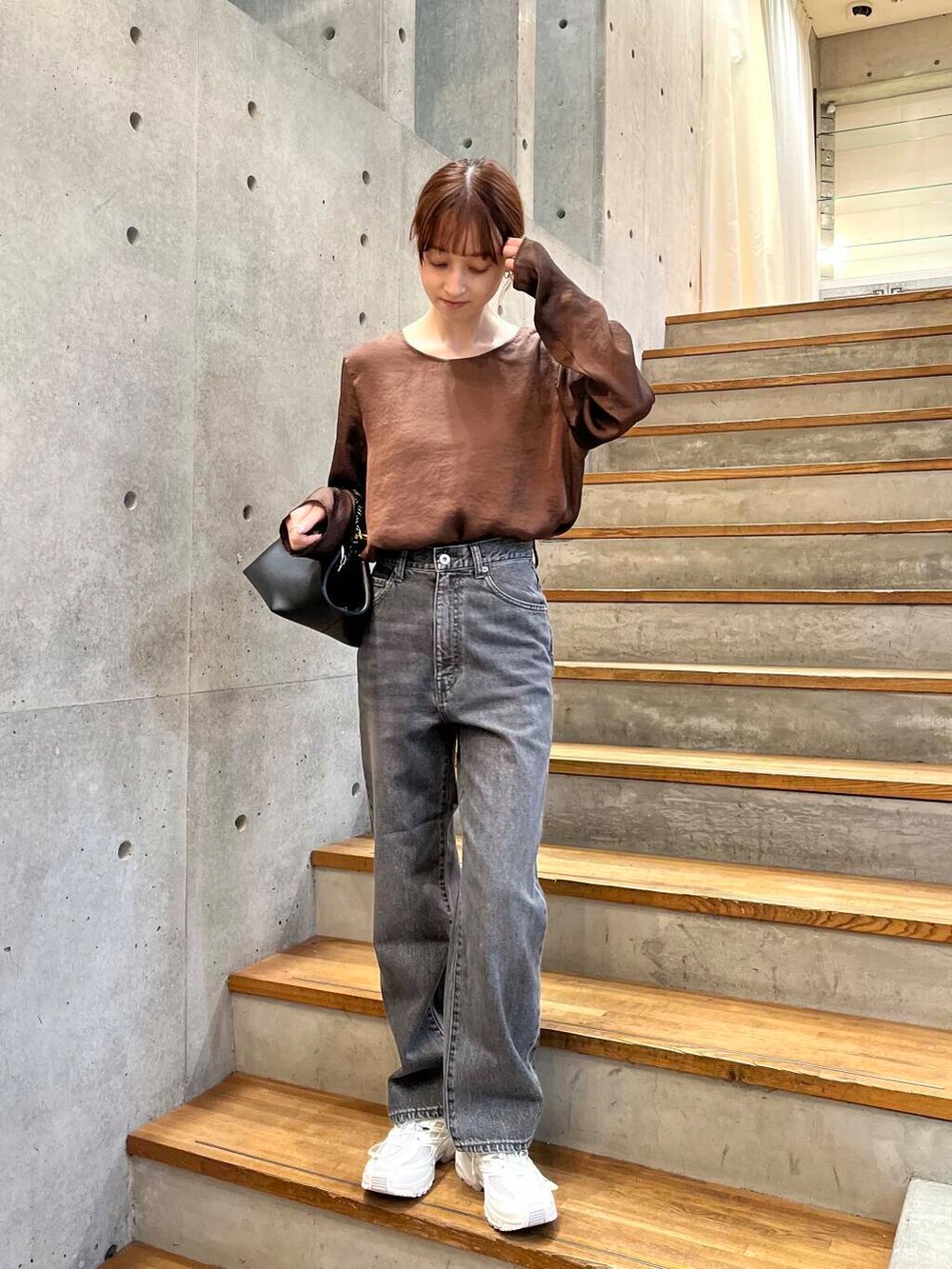 ブラウン系のシャツ/ブラウス、ブラック系のデニムパンツ、ホワイト系のスニーカーを着用したレディースの夏コーディネートの3枚目の写真