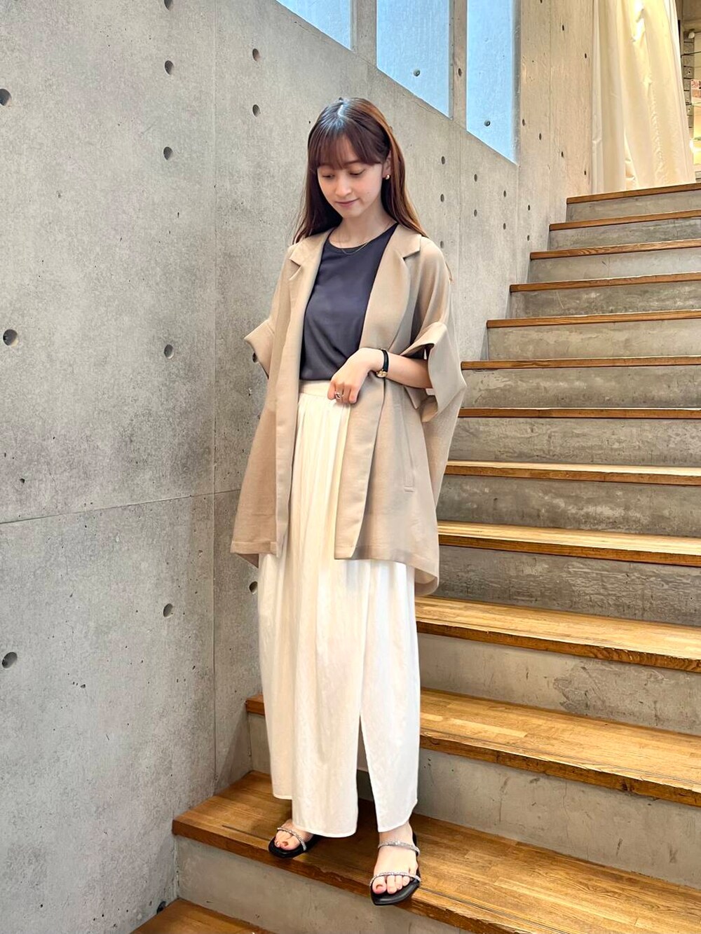 グレー系のTシャツ/カットソー、ブラック系のサンダル、ホワイト系のスカートを着用したレディースの夏コーディネートの4枚目の写真