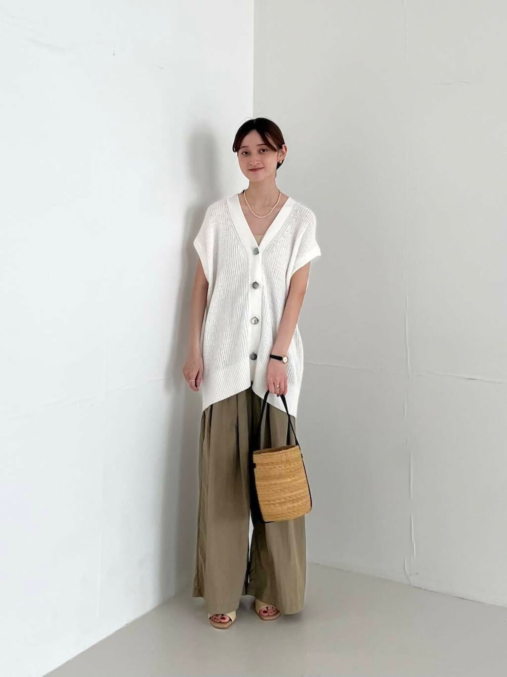 ベージュ系のその他パンツ、ベージュ系のかごバッグ、ベージュ系のサンダルを着用したレディースの夏コーディネートの3枚目の写真