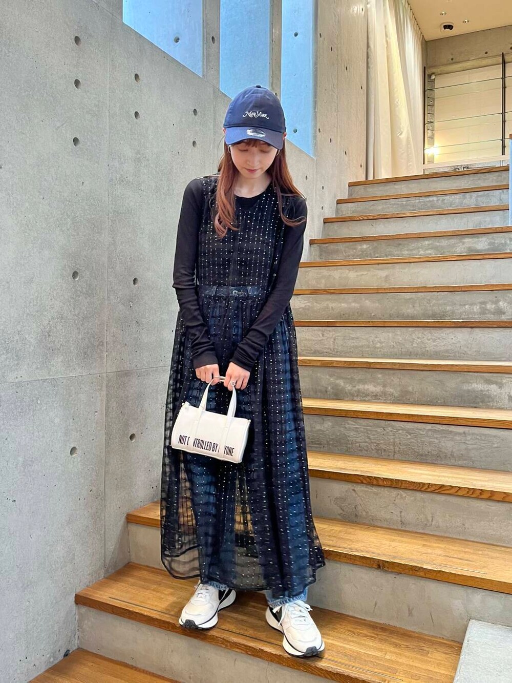 ブラック系のTシャツ/カットソー、ブルー系のデニムパンツ、ホワイト系のスニーカーを着用したレディースの夏コーディネートの2枚目の写真