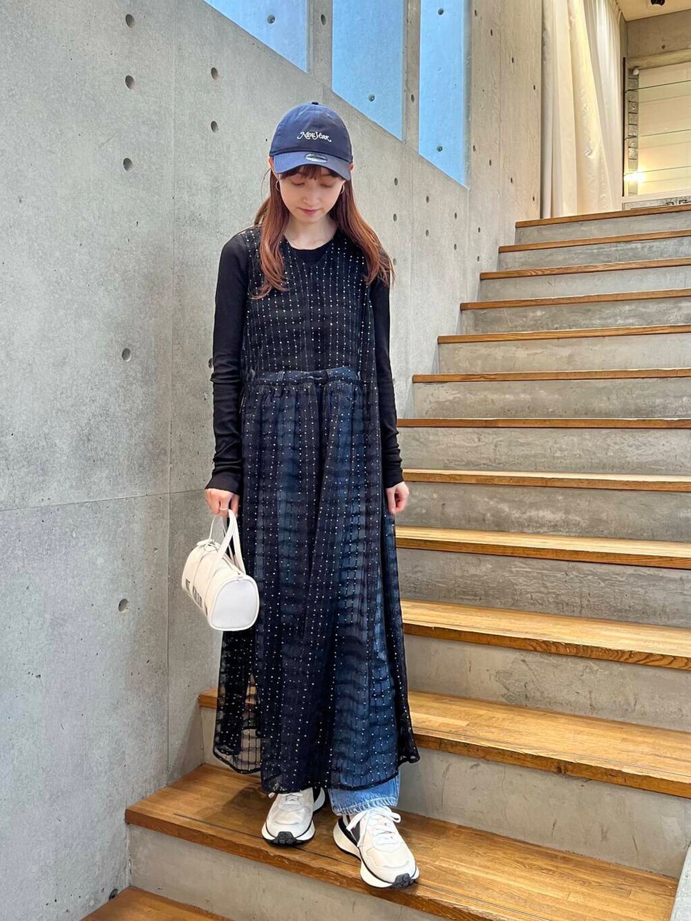 ブラック系のTシャツ/カットソー、ブルー系のデニムパンツ、ホワイト系のスニーカーを着用したレディースの夏コーディネートの4枚目の写真