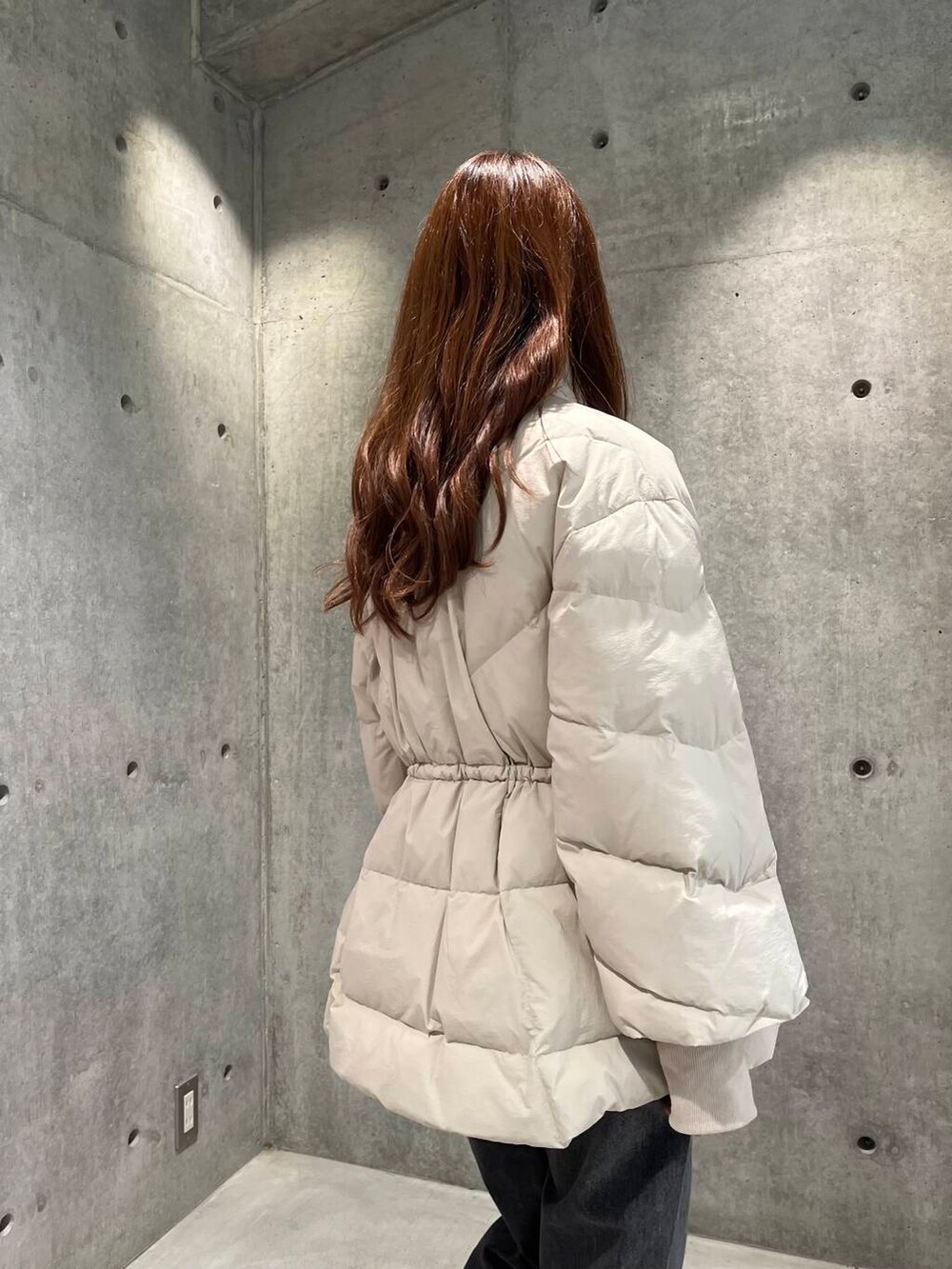 ブラック系のデニムパンツ、ブラック系のスニーカー、ホワイト系のダウンジャケット/コートを着用したレディースの秋コーディネートの10枚目の写真