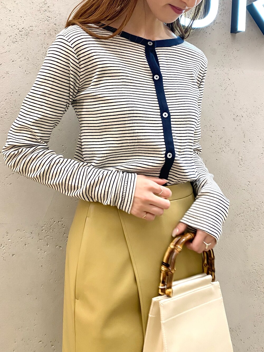 ブルー系のカーディガン/ボレロ、ベージュ系のその他アウター、イエロー系のスカートを着用したレディースの冬コーディネートの4枚目の写真