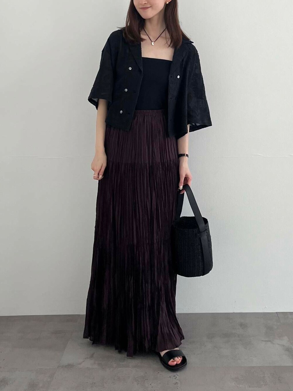 ブラック系のかごバッグ、ブラック系のサンダル、ブラウン系のスカートを着用したレディースの夏コーディネートの5枚目の写真