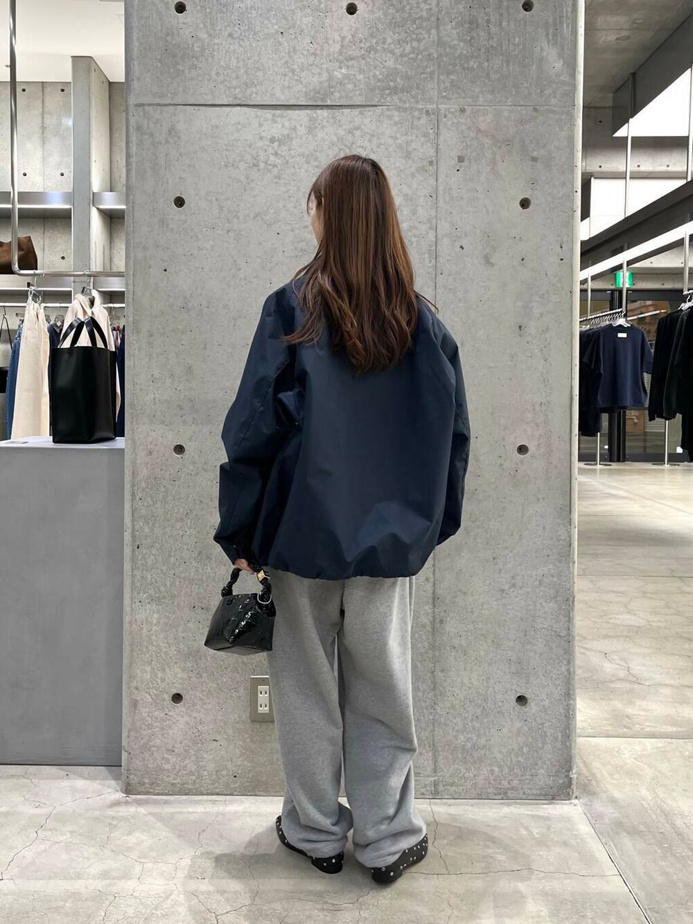 ブルー系のスウェット、ブラック系のショルダーバッグ、ブルー系のナイロンジャケットを着用したレディースの冬コーディネートの5枚目の写真