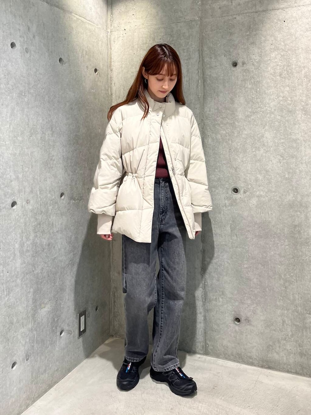 ブラック系のデニムパンツ、ブラック系のスニーカー、ホワイト系のダウンジャケット/コートを着用したレディースの秋コーディネートの5枚目の写真