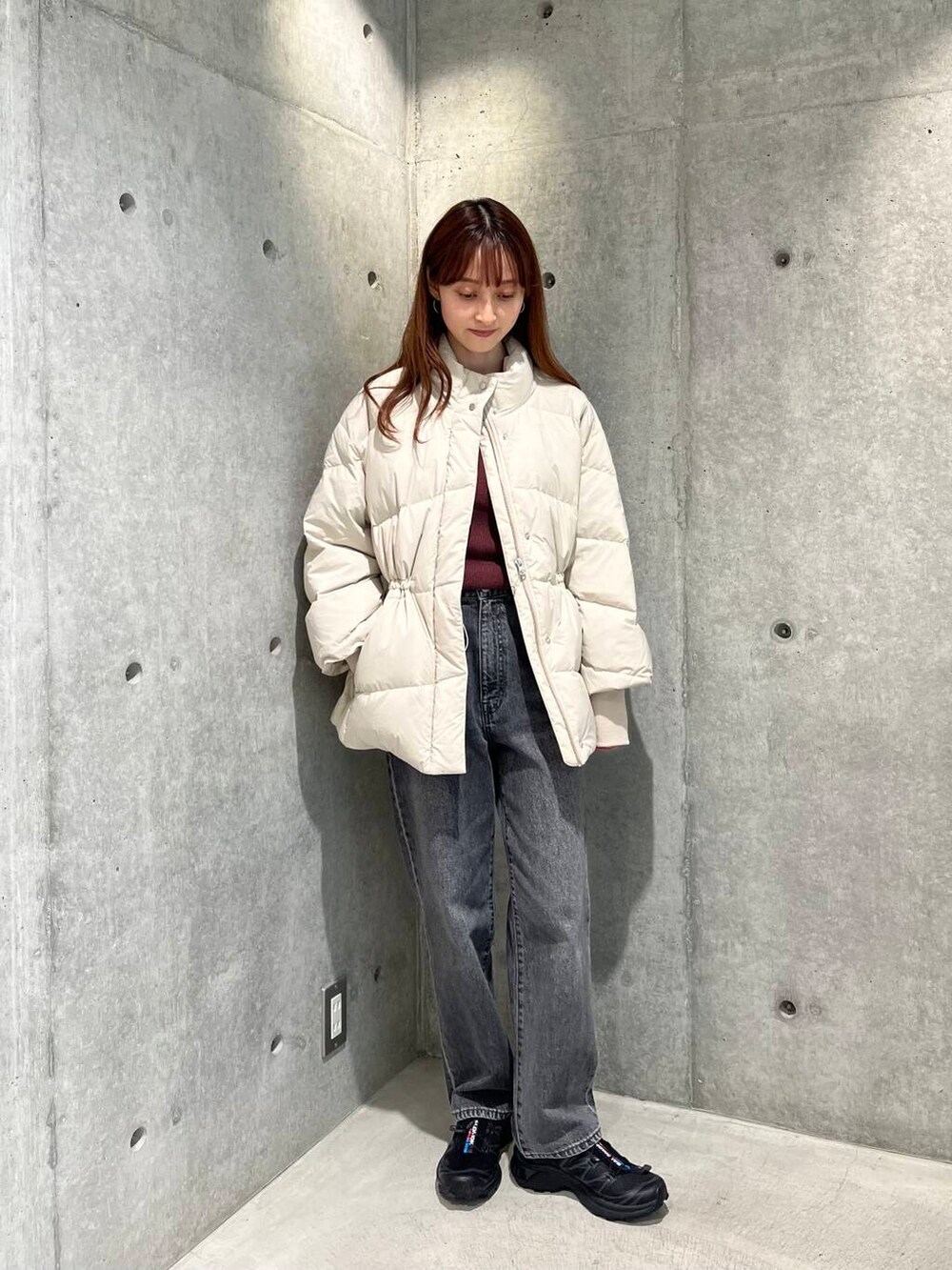 ブラック系のデニムパンツ、ブラック系のスニーカー、ホワイト系のダウンジャケット/コートを着用したレディースの秋コーディネートの6枚目の写真