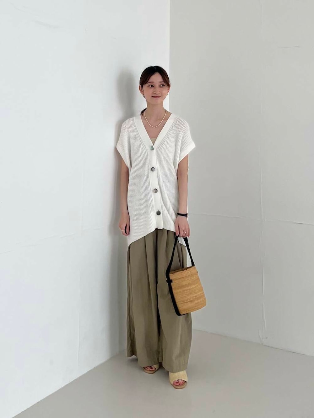 ベージュ系のその他パンツ、ベージュ系のかごバッグ、ベージュ系のサンダルを着用したレディースの夏コーディネートの2枚目の写真