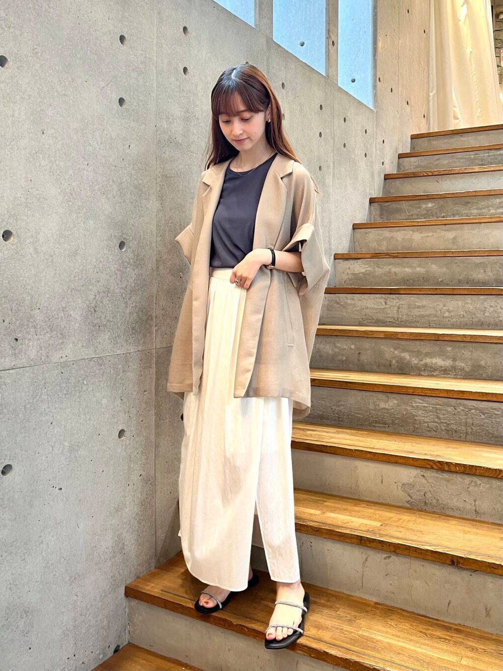 グレー系のTシャツ/カットソー、ブラック系のサンダル、ホワイト系のスカートを着用したレディースの夏コーディネートの5枚目の写真