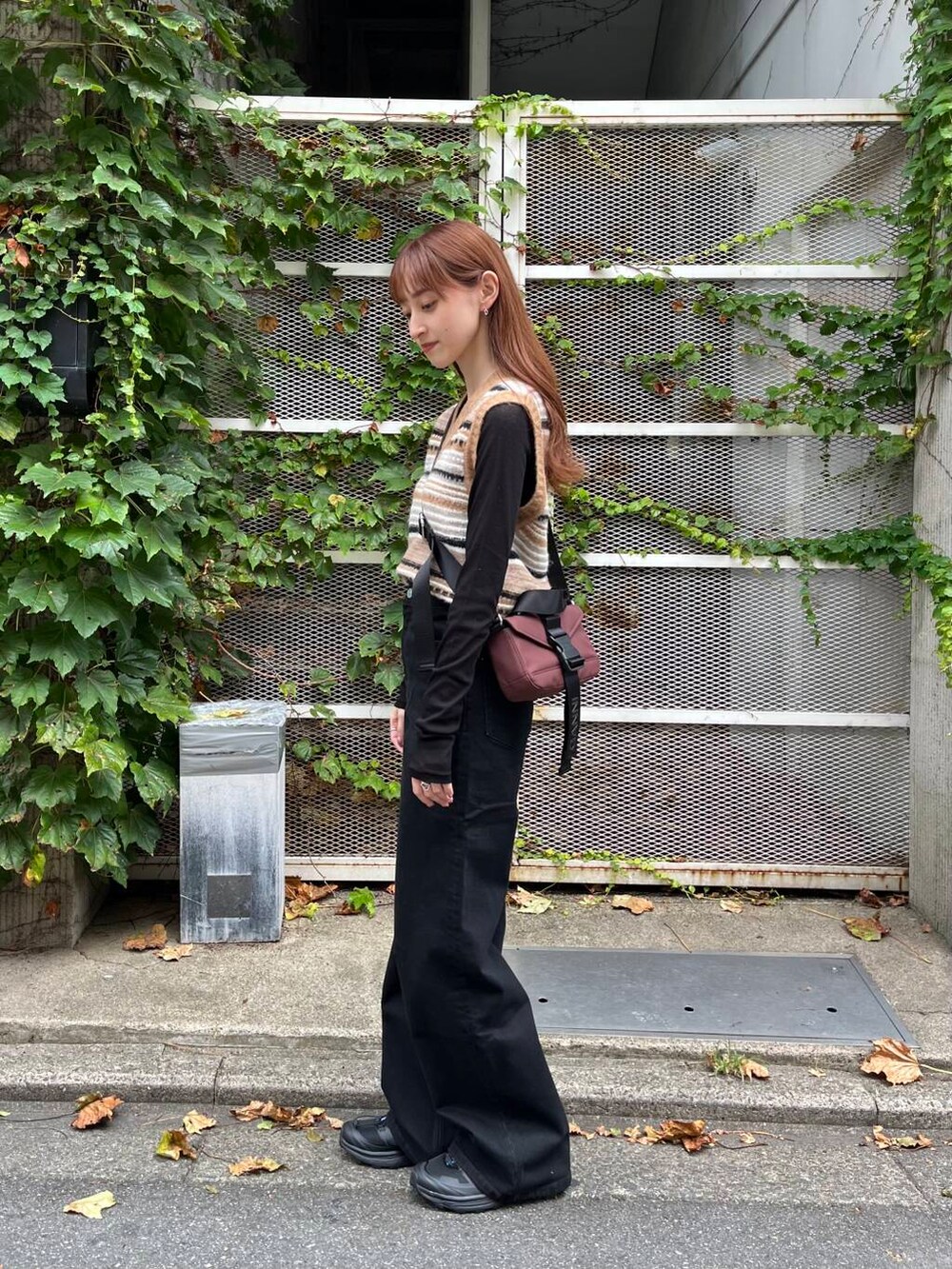 ブラック系のTシャツ/カットソー、ブラック系のスニーカー、ブラウン系のベストを着用したレディースの夏コーディネートの6枚目の写真