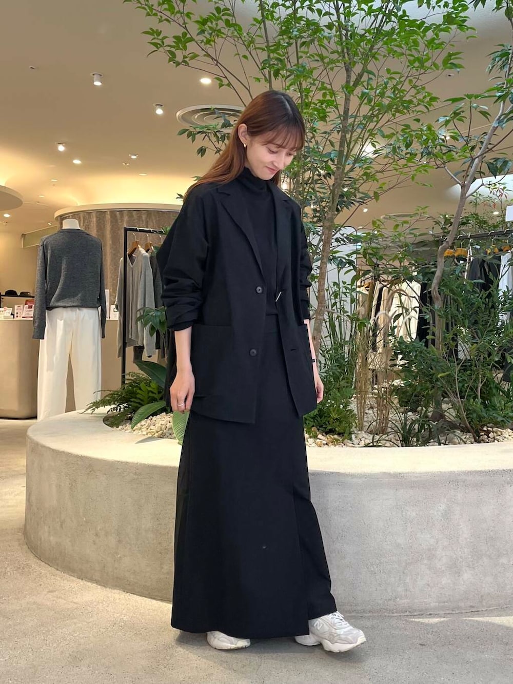 ブラック系のTシャツ/カットソー、ブラック系のテーラードジャケット、ブラック系のスカートを着用したレディースの秋コーディネートの4枚目の写真