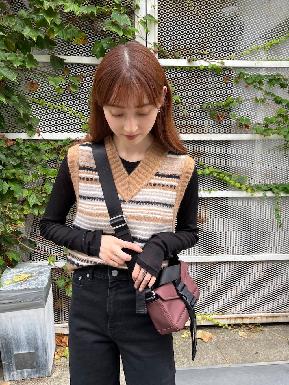 ブラック系のTシャツ/カットソー、ブラック系のスニーカー、ブラウン系のベストを着用したレディースの夏コーディネートの7枚目の写真