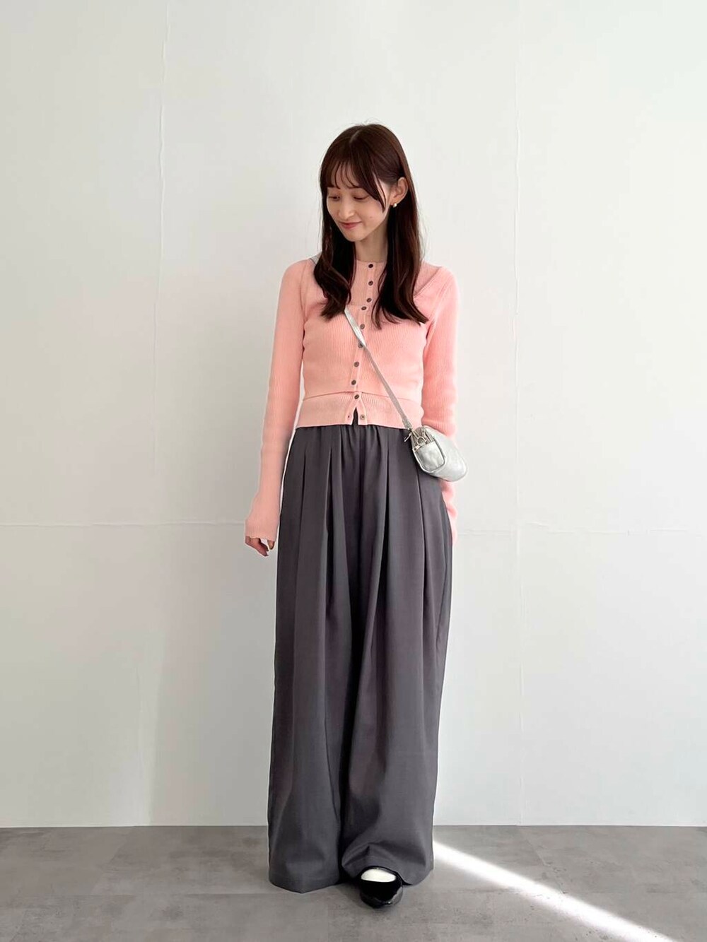グレー系のその他パンツ、シルバー系のショルダーバッグ、ピンク系のベストを着用したレディースの冬コーディネートの3枚目の写真