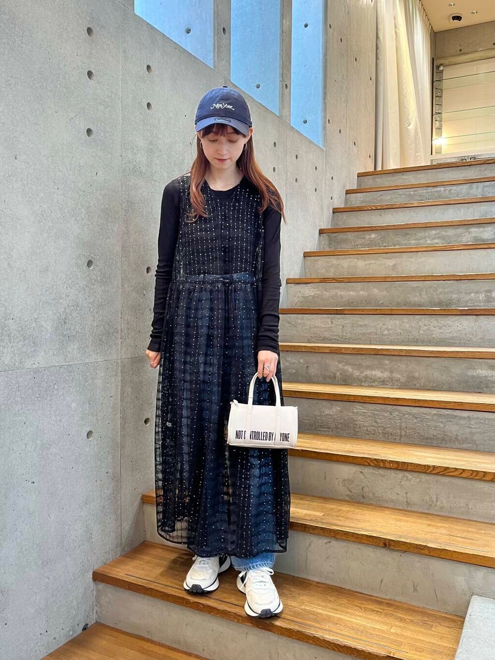 ブラック系のTシャツ/カットソー、ブルー系のデニムパンツ、ホワイト系のスニーカーを着用したレディースの夏コーディネートの6枚目の写真