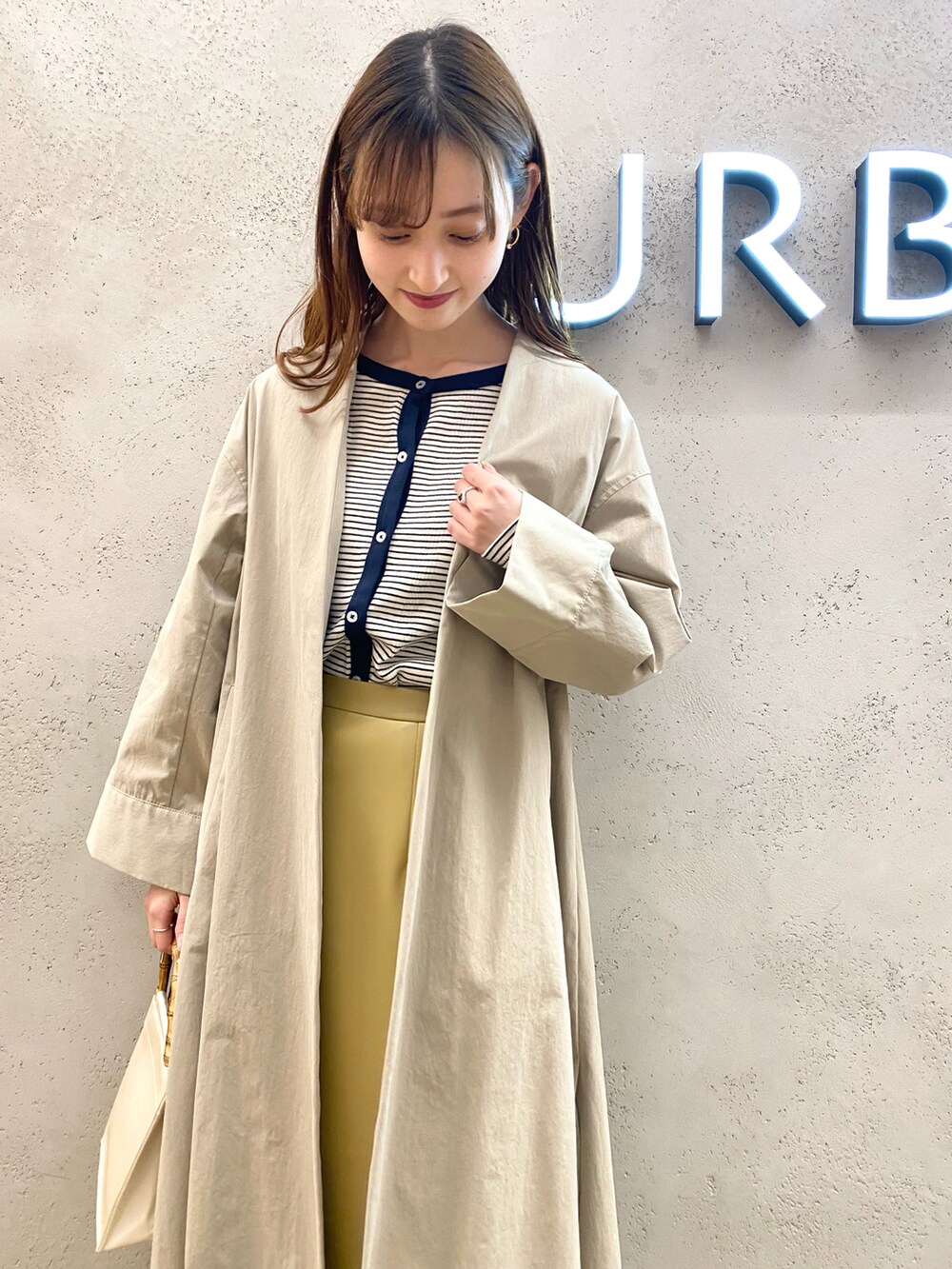 ブルー系のカーディガン/ボレロ、ベージュ系のその他アウター、イエロー系のスカートを着用したレディースの冬コーディネートの3枚目の写真