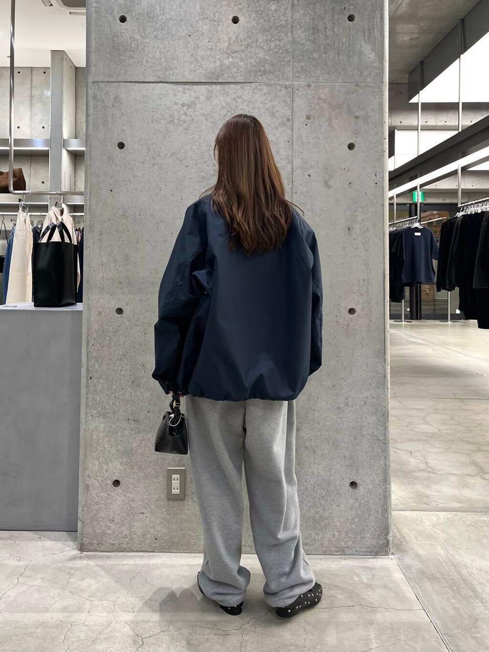 ブルー系のスウェット、ブラック系のショルダーバッグ、ブルー系のナイロンジャケットを着用したレディースの冬コーディネートの4枚目の写真