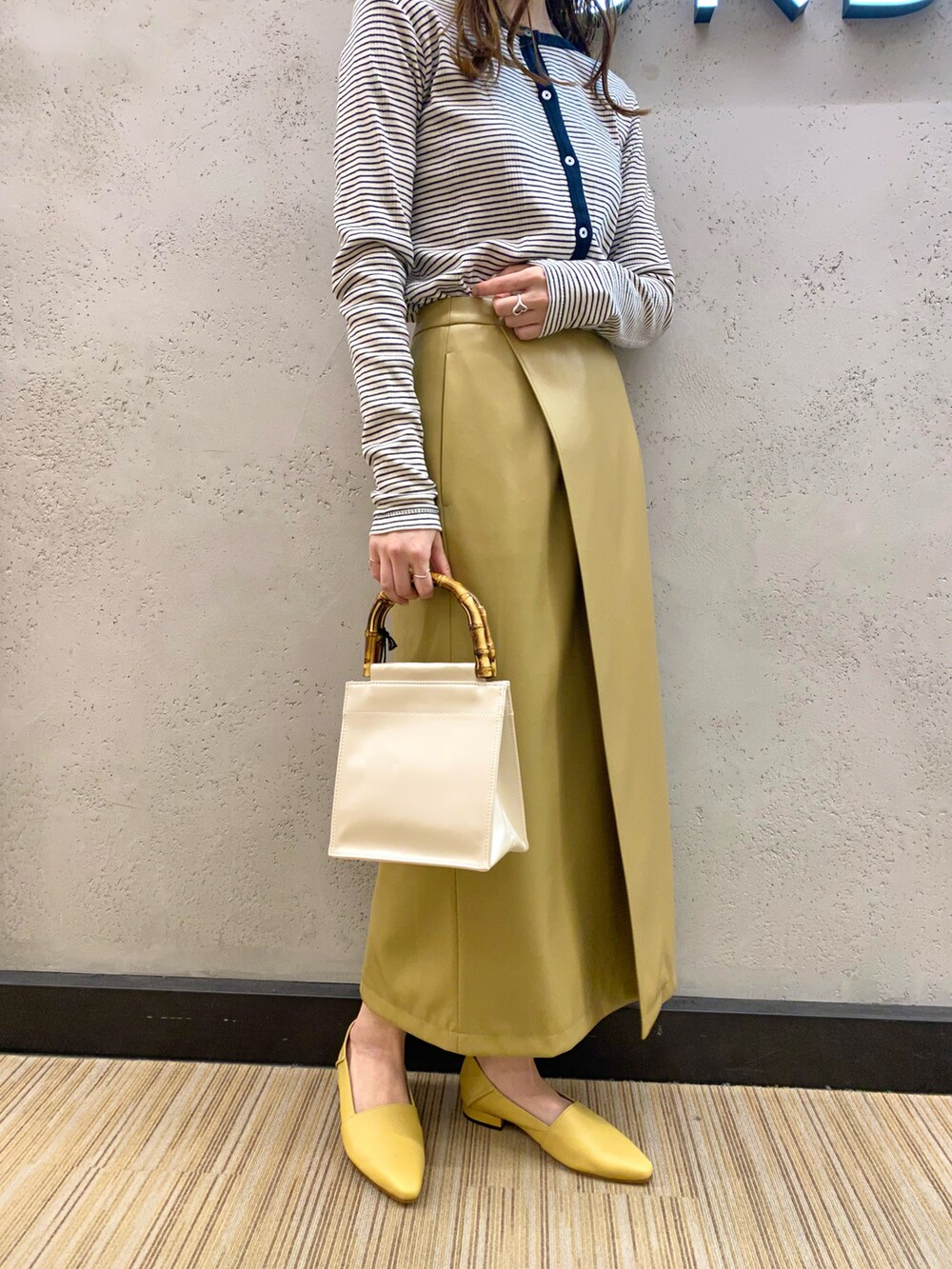 ブルー系のカーディガン/ボレロ、ベージュ系のその他アウター、イエロー系のスカートを着用したレディースの冬コーディネートの5枚目の写真