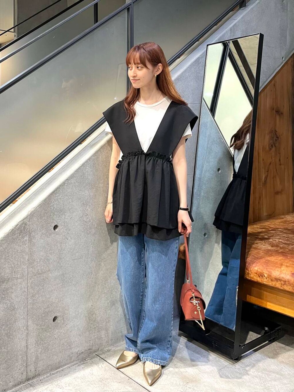 ゴールド系のパンプス、ブラウン系のショルダーバッグ、グレー系のTシャツ/カットソーを着用したレディースの夏コーディネートの2枚目の写真