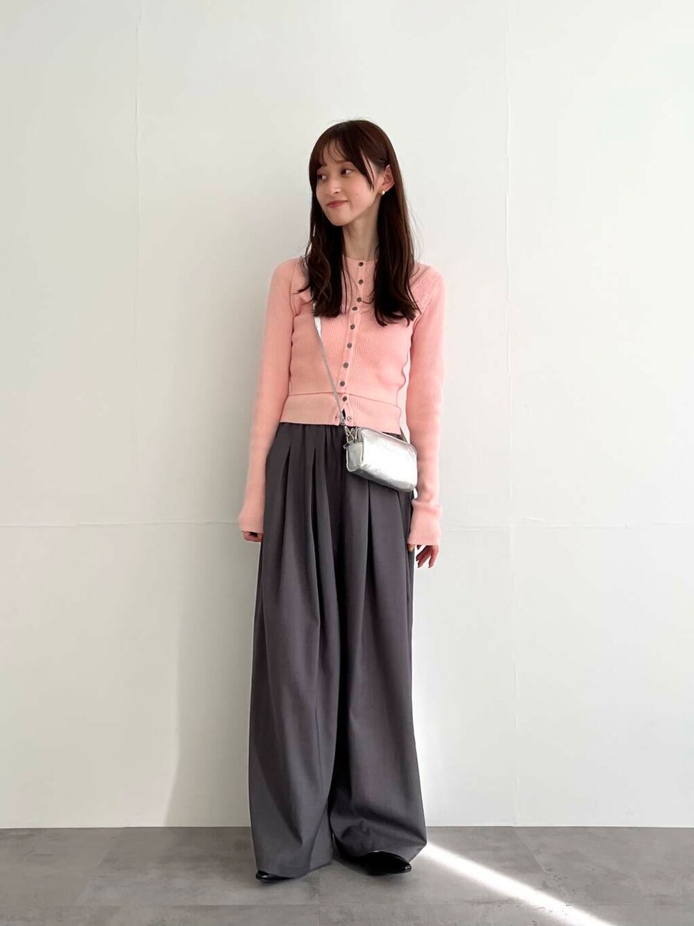 グレー系のその他パンツ、シルバー系のショルダーバッグ、ピンク系のベストを着用したレディースの冬コーディネートの4枚目の写真