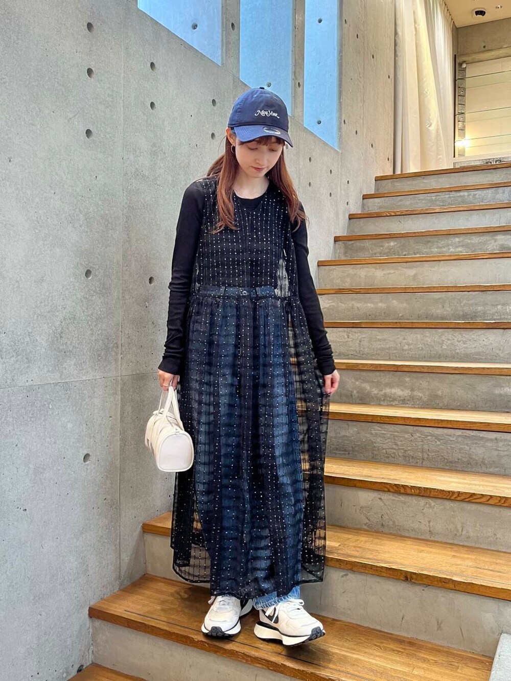 ブラック系のTシャツ/カットソー、ブルー系のデニムパンツ、ホワイト系のスニーカーを着用したレディースの夏コーディネートの5枚目の写真